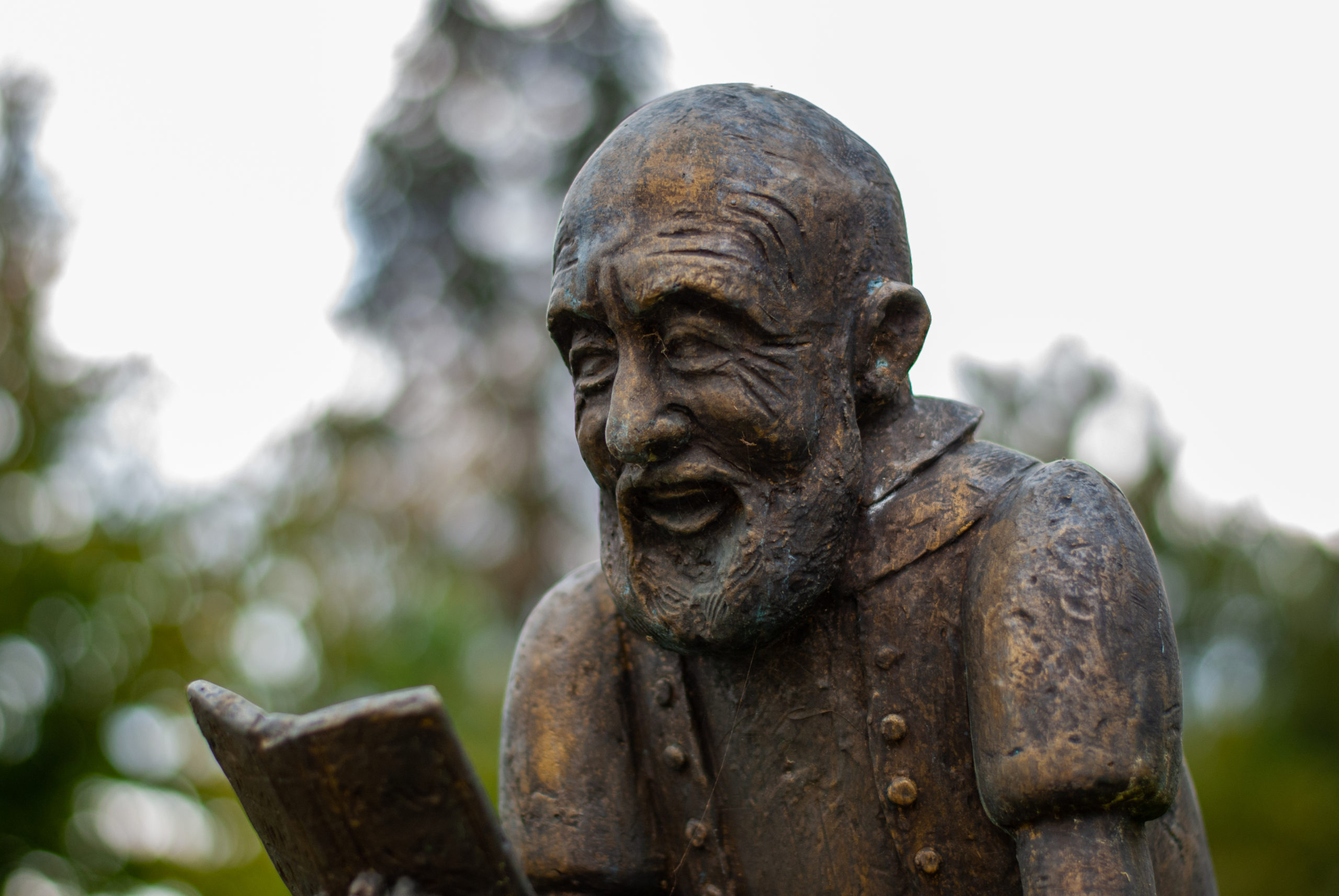 A statue smiling while reading